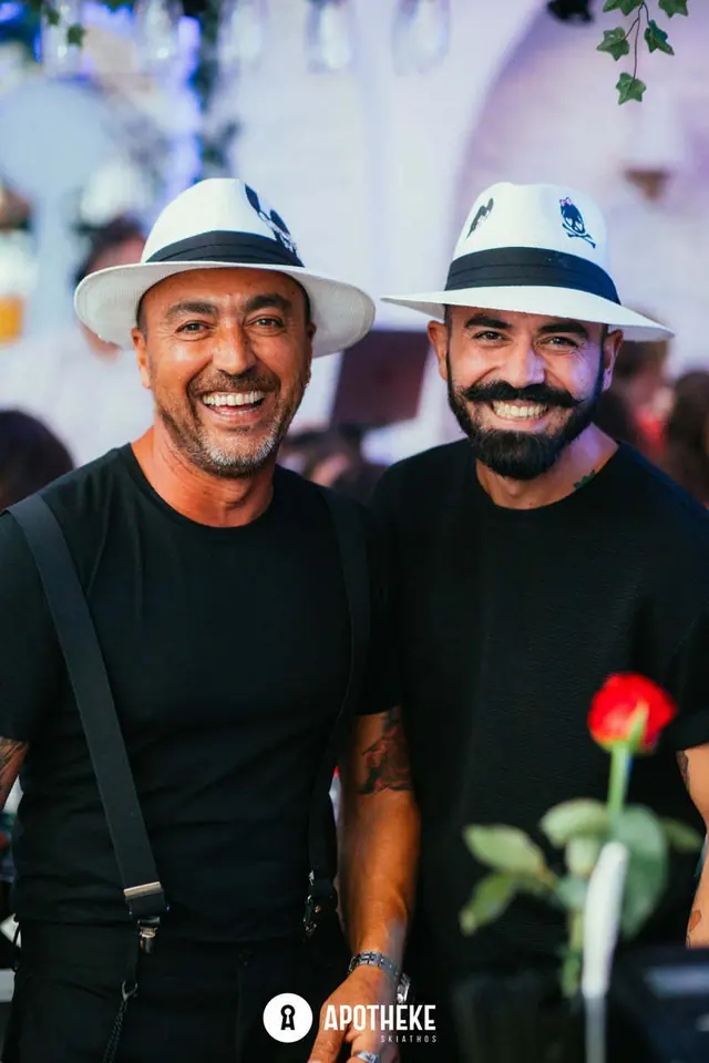 Δύο φίλοι με καπέλα και ένα κόκκινο τριαντάφυλλο