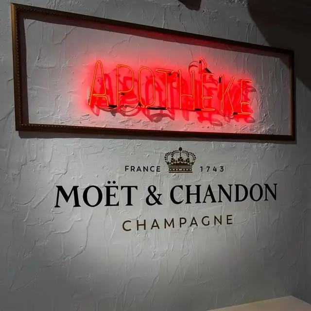 Η νέον πινακίδα «Apothèke» πάνω από τον τοίχο Moët & Chandon, 2026