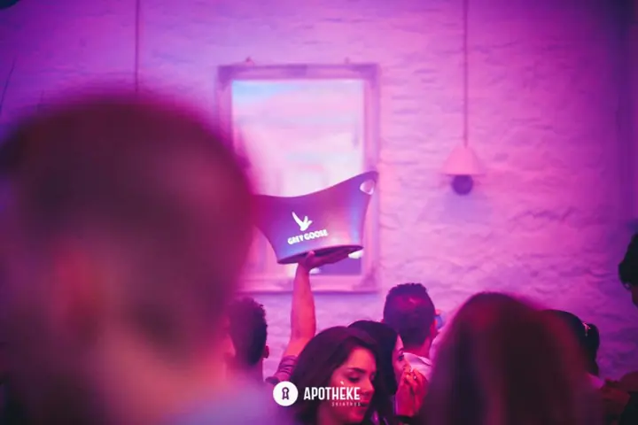 Ροζ φως και ένα μπουκάλι ψηλά πάνω από το πλήθος